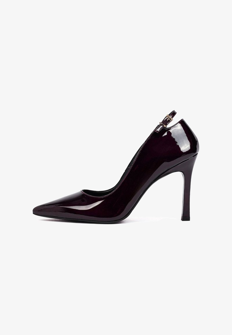 Escarpin en cuir verni bourgogne brillant avec un bout pointu, une silhouette épurée et un talon aiguille haut. Doté d'une fermeture éclair sur le côté.