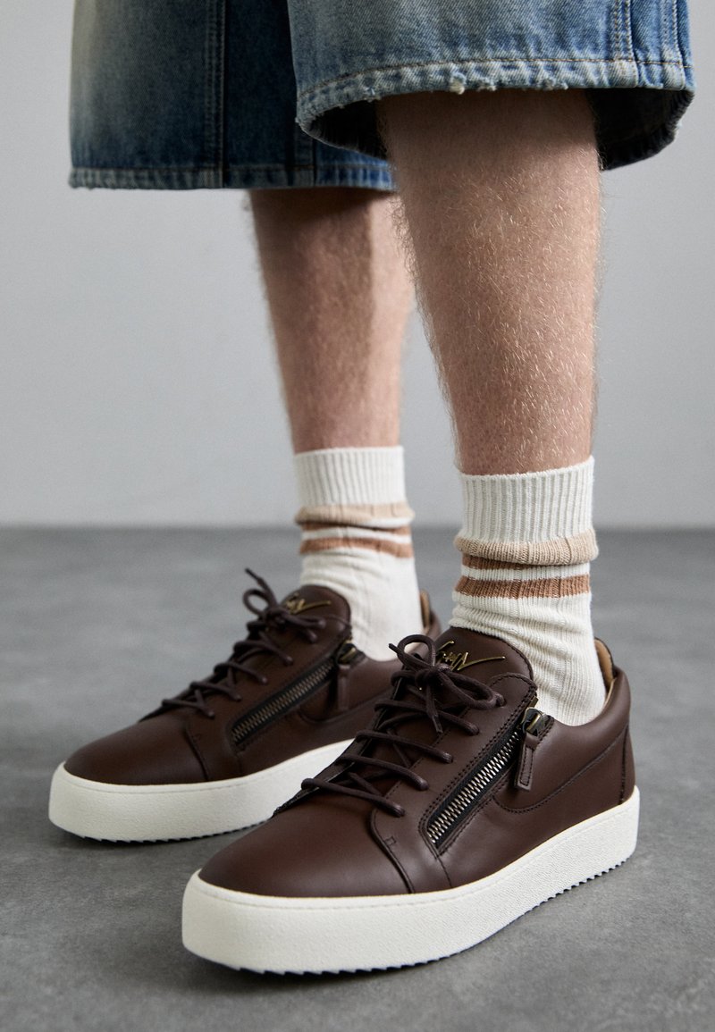 Pruunist nahast tossud valge tallaga, küljepeegeliga, lamepaeltega ja siledast tekstuurist. Kantud valgete ja beežide triibuliste sokkidega.