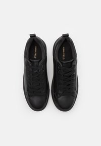 Svarta lädersneakers med rund tå och texturerade detaljer, med snörning och varumärkeslogga på innersulorna. Slät yta.