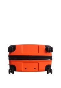 Bright orange hard-shell suitcase lying flat, showing four black spinner wheels and a black zipper around the middle.