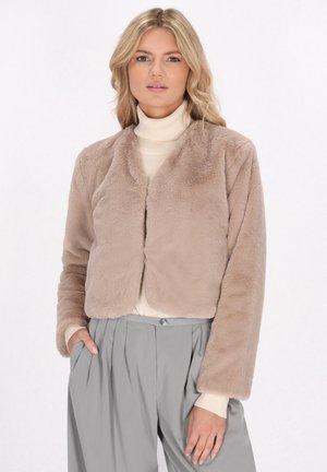 Neppelsjachrokk in beige, met een zachte textuur en een open voorkant. Gecombineerd met een crèmekleurige coltrui en grijze geplooide broeken.