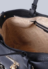 Svart texturerad handväska med guldhardware, dragkedjestängning. Inredningen har ett logotypmönstrat beige foder, en dragkedjeficka och gott om plats.