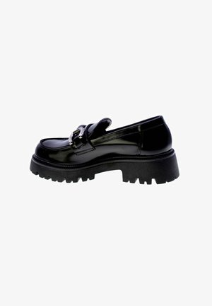 Mocassino nero con suola spessa in gomma, in pelle lucida, decorato con una fibbia e suola a gommini, vista laterale su sfondo bianco.