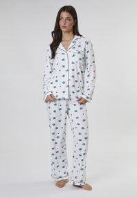 Weißes Pyjama-Set mit blauem und grünem Blumenmuster, bestehend aus langen Ärmeln, einem knopfbaren Oberteil mit Tasche und passenden Hosen.