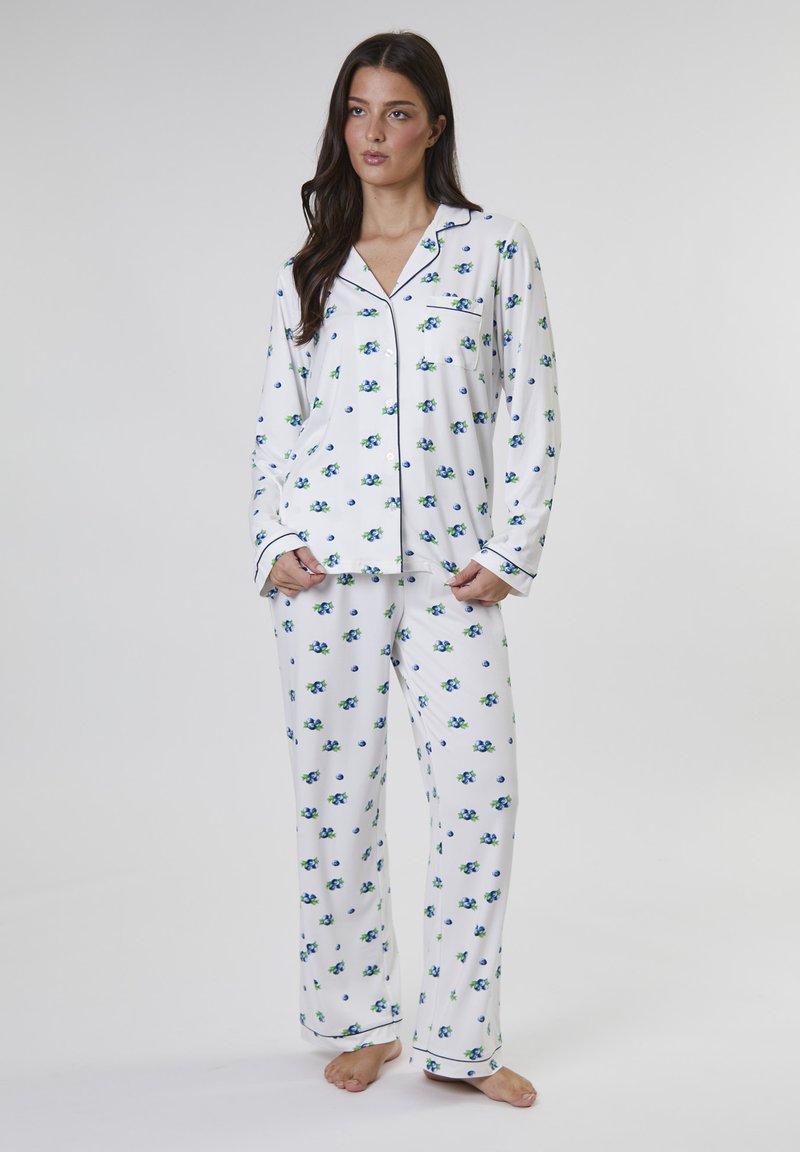 Weißes Pyjama-Set mit blauem und grünem Blumenmuster, bestehend aus langen Ärmeln, einem knopfbaren Oberteil mit Tasche und passenden Hosen.