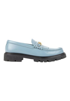 Mocassin en cuir bleu clair avec semelle en caoutchouc noir épaisse et détail de boucle en métal doré sur la tige, présenté de profil sur fond blanc.