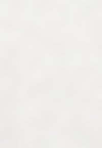 Mur blanc avec une texture lisse et des variations subtiles de teinte, créant une apparence visuelle monochromatique et minimaliste.