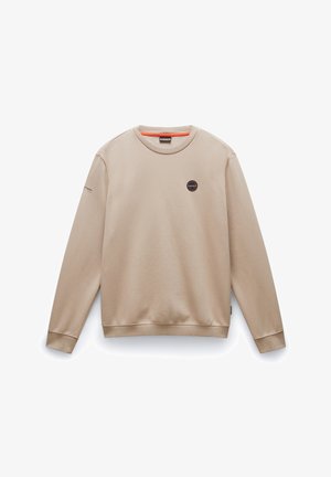 Beżowy sweter z długimi rękawami, okrągłym dekoltem, miękką teksturą, centralną naszywką z logo oraz kontrastowym szczegółem wewnętrznego kołnierza w kolorze pomarańczowym.