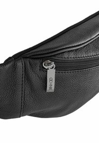 Czarna torebka na talię z teksturowanej skóry z widocznym zamkiem błyskawicznym i metalowym uchwytem z logo "OCHNIK" na białym tle.