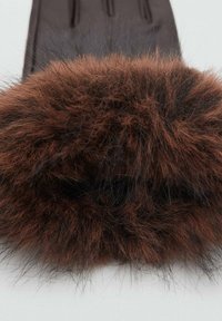 Guantes marrones con un puño de piel de pelaje suave y esponjoso en tonos de marrón oscuro y claro, y un material similar al cuero para el cuerpo principal.