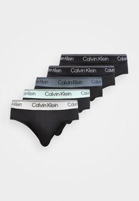 Cinco pares de calzoncillos tipo slips para hombre en negro con cinturillas de la marca Calvin Klein en blanco, menta, gris y dos variaciones de color negro.