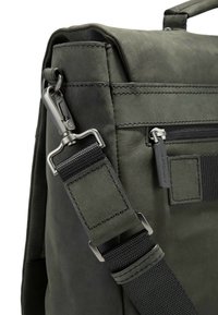 Borsa a tracolla in pelle verde scuro con superficie texturizzata, tracolla regolabile in nylon nero e dettagli metallici.