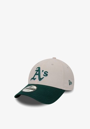 Baseball cap with a beige crown and a dark green brim. Features an embroidered "A's" logo in green on the front. New Era tag visible.