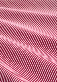 Czerwono-biała materiał z paskami w miękkiej teksturze, z falującymi liniami tworzącymi rytmiczny wzór na tkaninie.