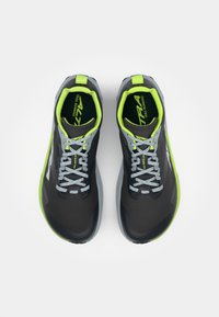 Des chaussures de trail de course noires et grises avec des accents vert fluo, dotées d'un dessus texturé, de lacets gris et d'une semelle rembourrée.