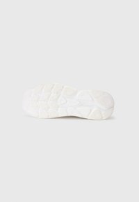 Semelle de chaussure en caoutchouc blanc avec un motif texturé. Présente des rainures et des formes variées pour une meilleure adhérence et flexibilité.