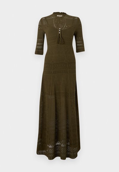 Μακρύ πλεκτό φόρεμα σε ελιά πράσινο με μανίκια μέχρι το αγκώνα, περίπλοκα δαντελένια σχέδια, κούμπωμα στο ντεκολτέ και κορδόνια με φούντες.
