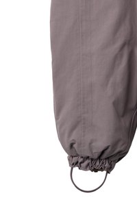 Szare spodnie outdoorowe z elastycznymi mankietami i detalem w postaci pętli. Wykonane z gładkiej, lekkiej tkaniny o subtelnej strukturze i precyzyjnym przeszyciu.