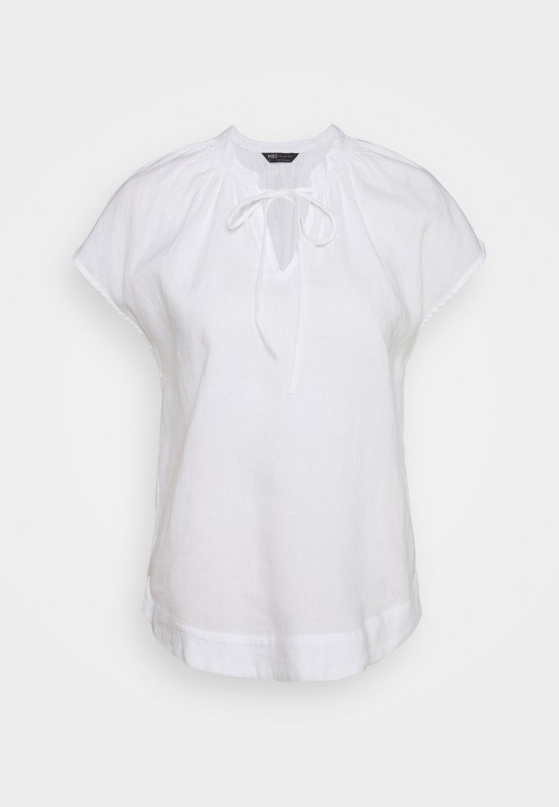 Blouse blanche à manches courtes avec encolure ronde, ouverture en forme de clé à l'avant et fermeture par lien, fabriquée en tissu léger.