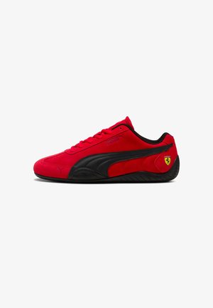 Roter Puma Sneaker mit niedrigem Schaft, schwarzem Streifen und Ferrari-Logo an der Ferse, dargestellt vor weißem Hintergrund.