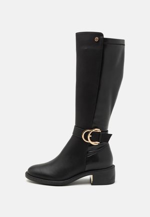 Botas negras hasta la rodilla hechas de cuero suave, con un doble hebilla dorada en forma de círculo y un bajo tacón cuadrado. Diseño simple sin patrones.