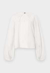 Λευκό μπλούζα με μακριά φουσκωτά μανίκια από δαντέλα με οπές και μικρό φιόγκο στο ντεκολτέ, με ίσια γραμμή και ελαφρύ ύφασμα.