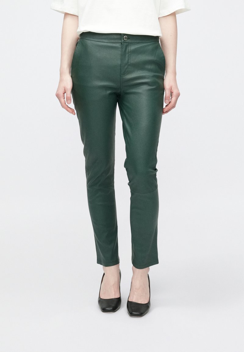Groene namaakleren broek met een strakke pasvorm, enkelhoogte, ritssluiting aan de voorkant en knoopsluiting. Soepele textuur en minimale details.