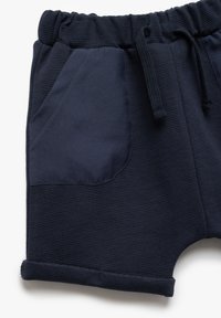 Mørkeblå shorts i struktureret stof med en stor sidelomme i glat mørkeblåt materiale og en elastisk talje med snoretræk.