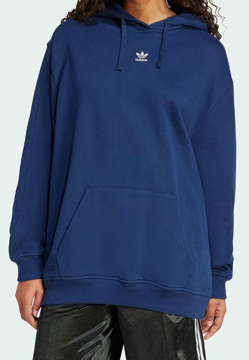 Sudadera de color azul marino hecha de un tejido suave, con un bolsillo canguro, capucha con cordones y el logo blanco de Adidas en el pecho.
