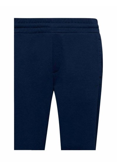 Pantaloni jogging blu navy realizzati in tessuto morbido. Presentano una vita elasticizzata e tasche laterali. Design semplice senza motivi visibili.
