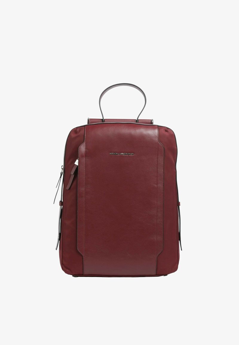 Zaino in pelle bordeaux con forma rettangolare, manico superiore, lati con zip e dettagli di cucitura sottili. Presenta un logo sulla parte frontale.