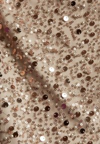 Rosaguldigt paljetttyg med pärlaccents, med en genomskinlig bas. Runda platta paljetter och små pärlor skapar en texturerad, reflekterande yta.