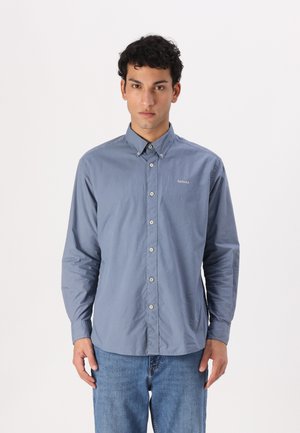 Lange mouwen, knoopsluiting shirt in lichtblauwe stof, met een kraag, vooraan knoopsluiting en subtiele Barbour-logo op de borst.