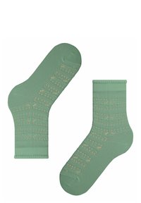 Grüne Baumwollsocken mit einem helleren grünen gemusterten Design, das dekorative Löcher und gerippte Bündchen aufweist.