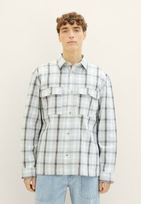 Kariertes Hemd in Hellblau und Weiß, mit schwarzen Akzenten, Kragendesign, zwei Vorderaschen und Knopfverschlüssen. Weicher Stoff.