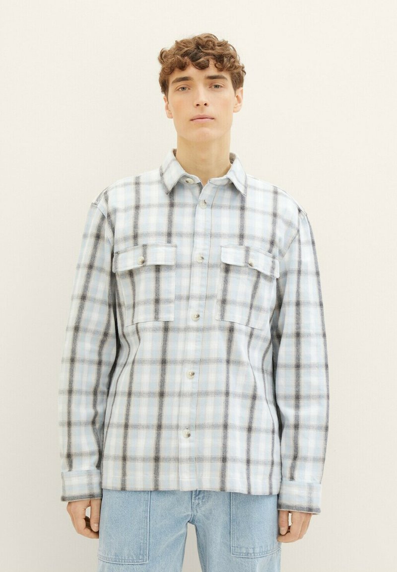 Kariertes Hemd in Hellblau und Weiß, mit schwarzen Akzenten, Kragendesign, zwei Vorderaschen und Knopfverschlüssen. Weicher Stoff.