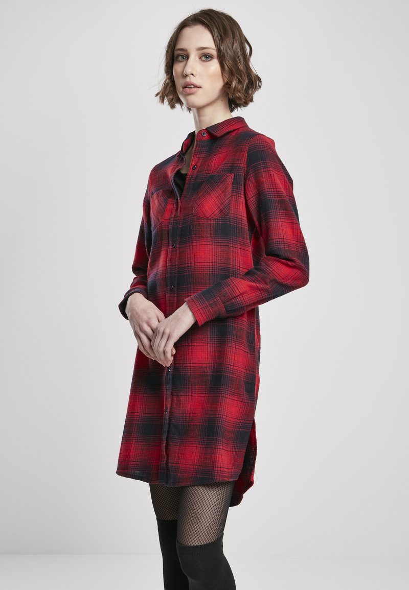 Robe chemise en flanelle à carreaux rouges et noirs, avec un col, une fermeture à boutons, deux poches poitrine et des manches longues. Tissu texturé.