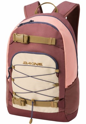 Rosa und beige Dakine Rucksack mit vorderem elastischem Kordelzug, zwei hellbraunen Schnallenriemen, Reißverschlusstaschen und gepolsterten Schultergurten.