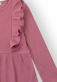 Vestido rosa acanalado con mangas largas, que presenta un volante a lo largo de la costura del hombro y una falda acampanada. Textura suave, diseño casual.