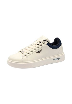 Sneaker in pelle bianca con punta arrotondata, suola piatta, dettagli navy e logo metallico. Presenta un design con lacci e suola testurizzata.