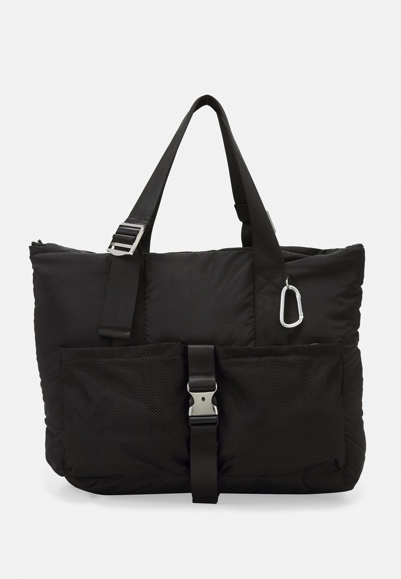 Grand sac cabas noir avec deux poignées, poche avant en maille avec sangle à boucle, bandoulière réglable et mousqueton en métal.