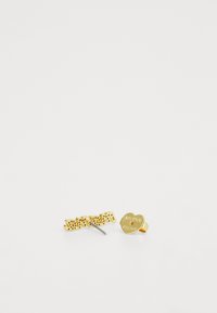 Kultaiset korvakorut, joissa on sanamuotoilu ja sydämenmuotoinen yksityiskohta. Pintakuviointi, jossa näkyy yksityiskohtia molemmissa osissa.