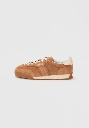 Sneakers in camoscio marrone con dettagli perforati, accenti crema e una suola testurizzata. Presentano strisce a contrasto e una linguetta con marchio sul lato.