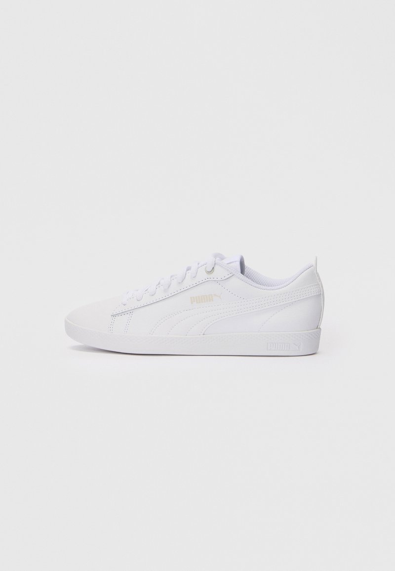 White athletic shoe made of smooth synthetic material, featuring laces, subtle Puma logo in gold, and a textured rubber sole.