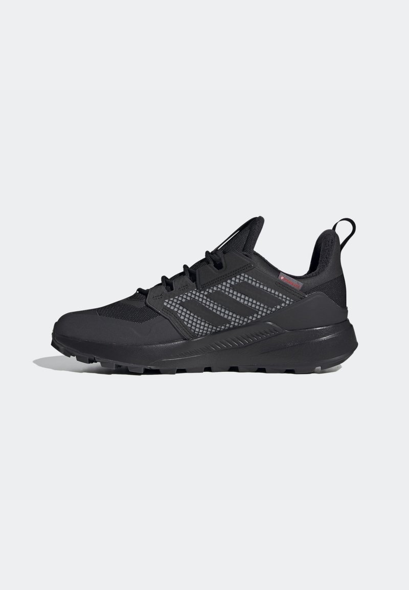Chaussure de sport noire avec semelle texturée, dessus en mesh et synthétique, trois bandes latérales, design à lacets et languette au talon.