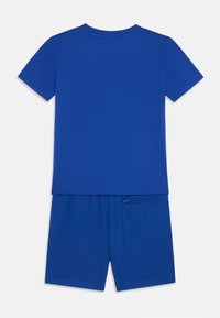 Conjunto de camiseta de manga corta y pantalones cortos de color azul. La camiseta tiene una textura suave; los pantalones cortos presentan un diseño de malla con un pequeño bolsillo lateral.