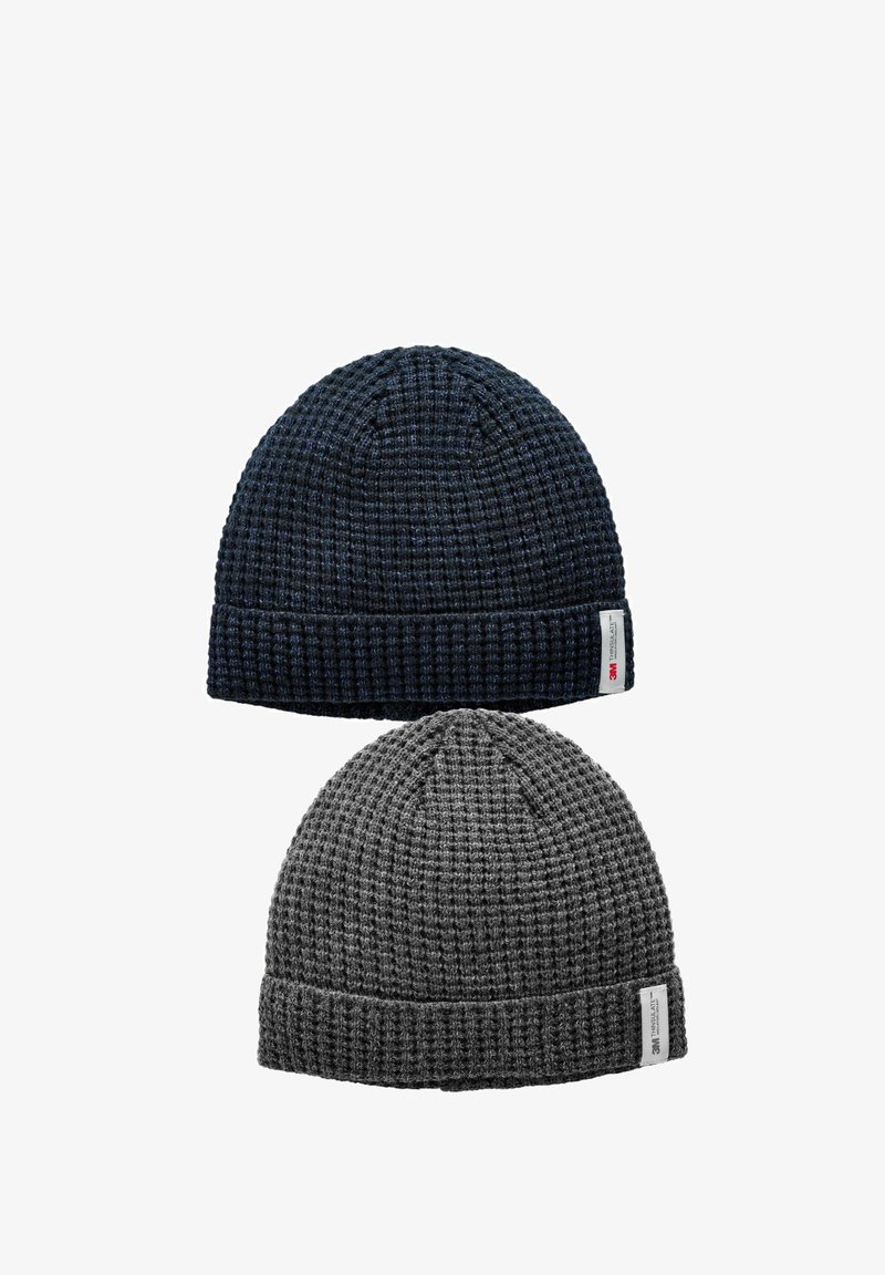 Two knitted beanies: one dark blue, one gray. Both feature a ribbed texture and a folded cuff with a sewn brand label.
