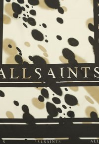 Un tejido estampado en negro y crema presenta manchas irregulares sobre un fondo crema, bordeado por líneas negras con el texto "ALLSAINTS".