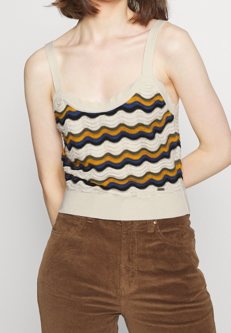 Pletené béžové tílko s vlnitými vícebarevnými pruhy (žlutá, modrá, černá) a texturovaným vzorem; má ramenní popruhy a přiléhavý lem.