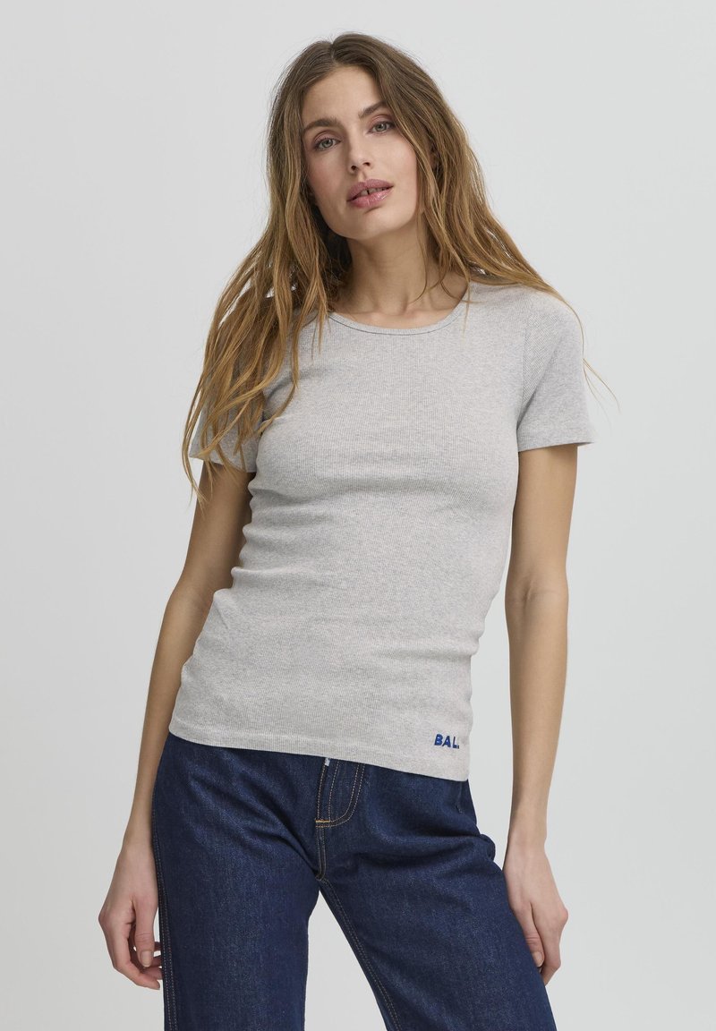 Světle šedé tričko s krátkým rukávem v žebrované textuře a přiléhavém střihu. Obsahuje malé modré logo "BAL" poblíž lemu. Spárováno s tmavě modrými džíny.